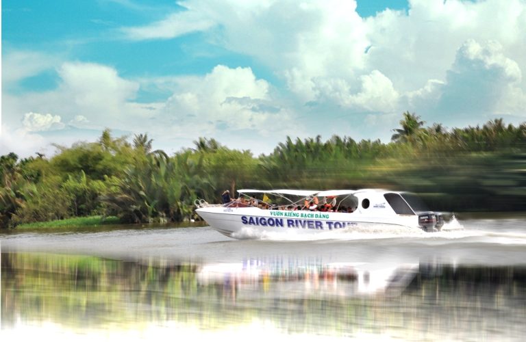 Luxury speedboat cruising on the Saigon River towards Cu Chi Tunnels